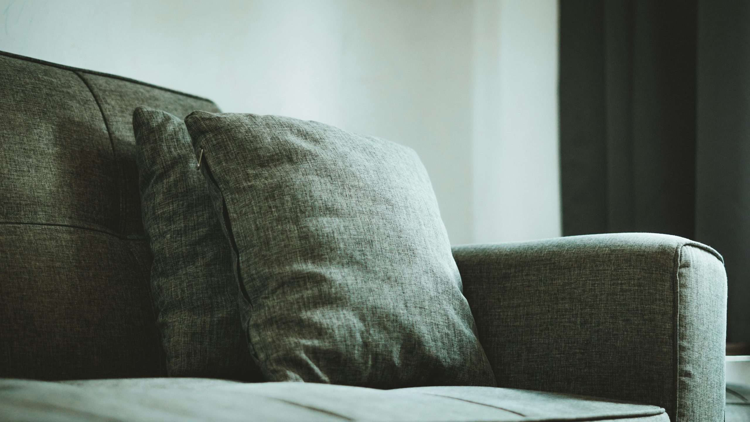 A close-up of a modern gray sofa with plush cushions, creating a cozy setting in a Jakarta home.